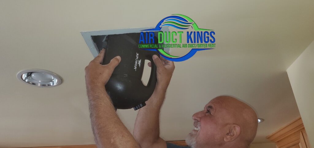 Technician removing an exhaust fan housing for cleaning
