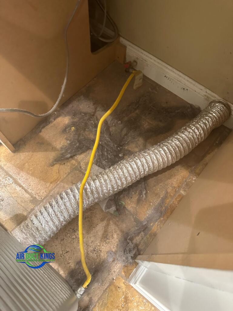 New metal dryer vent duct installed behind a dryer