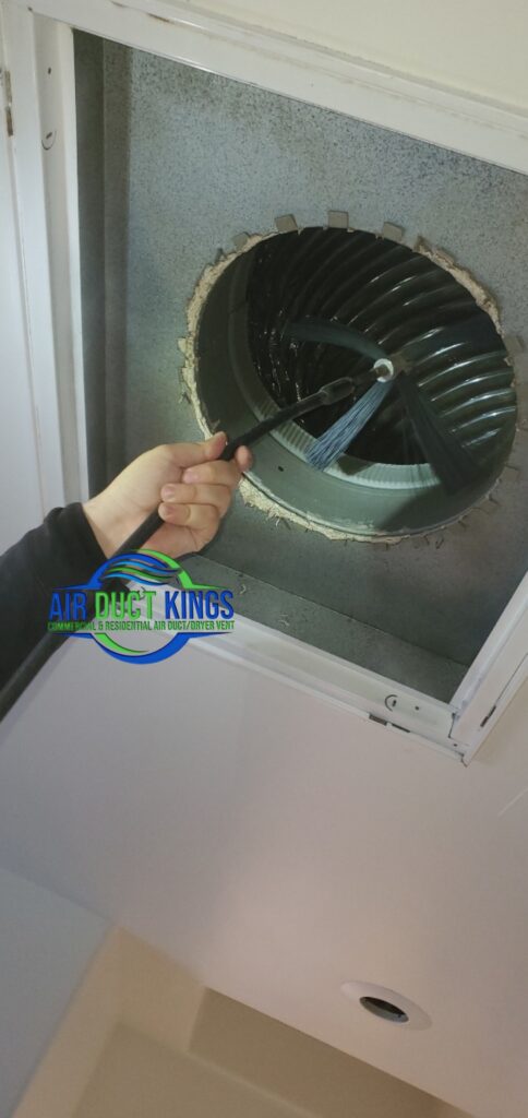Technician cleaning inside an air duct register in Orange County